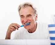 an older man brushing his teeth in the morning